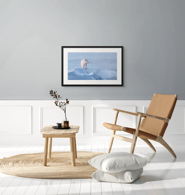 Modern interior with a framed artwork, wooden chair, and side table.
