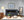 Modern living room with a fireplace, sofa, and decorative items. Photograph of polar bear displayed above fireplace.