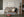 Wooden bench with cushions in a room with a framed picture on the wall.