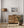 Wooden dresser with a framed picture of a leopard, floor lamp, and plant in a room.